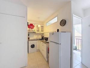 a kitchen with a refrigerator and a washer and dryer at Appartement T2 avec Piscine à Vieux-Boucau - FR-1-857-52 in Vieux-Boucau-les-Bains +2 photos