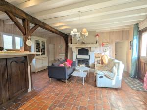 Una sala de estar con dos sillas y una chimenea. en Charmant hébergement avec parc et étang à Mers-sur-Indre - FR-1-591-771, en Bonnet