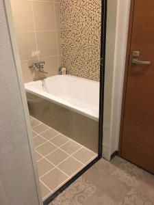 柏市にあるホテルリンクス柏市豊四季店のタイルフロアのバスルーム(バスタブ付) +3枚の写真