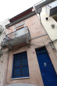 un edificio con due porte blu e un balcone di NonnAnna Short Lets ad Alcamo