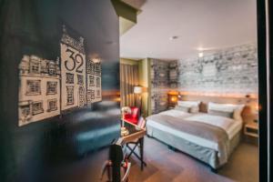 a bedroom with a large bed and a desk with a desk at BALTAZÁR Boutique Hotel in Budapest