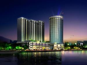 ein Gebäude mit zwei hohen Türmen neben einem Gewässer in der Unterkunft New Century Hangzhou Qiandao Lake Longting Hotel in Thousand Island Lake