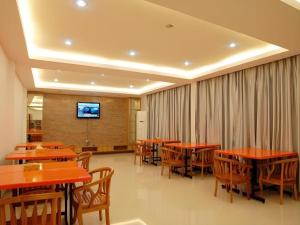 Un comedor con mesas y sillas y un televisor. en Super 8 Hotel Fuzhou Jinjishan, en Fuzhou
