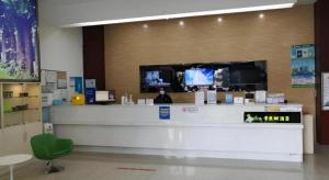a store with a counter with a tv on the wall at Vatica Lianyungang Haizhou Xinkong South Road Zhongyin Mingdu Hotel in Yuhang +16 photos