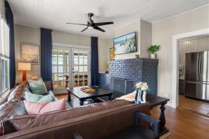 a living room with a couch and a fireplace at Be A Nomad - Historic 6BR Cottage Steps to Jacksonville Beach Sleeps 12 in Jacksonville Beach
