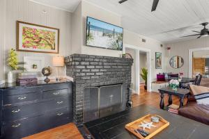 a living room with a fireplace and a couch at Be A Nomad - Historic 6BR Cottage Steps to Jacksonville Beach Sleeps 12 in Jacksonville Beach