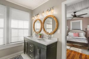 a bathroom with a sink and a mirror at Be A Nomad - Historic 6BR Cottage Steps to Jacksonville Beach Sleeps 12 in Jacksonville Beach
