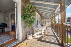 a porch of a house with a potted plant at Be A Nomad - Historic 6BR Cottage Steps to Jacksonville Beach Sleeps 12 in Jacksonville Beach