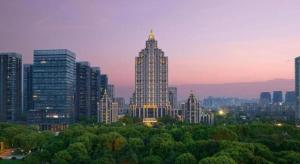 a city skyline with tall buildings and trees at dusk at Tongxiang Inspirock Hotel in Tongxiang
