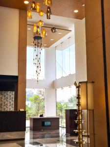 Un vestíbulo con un gran ventanal y una lámpara de araña. en Parays Fernwoods, en Mannārakkāt