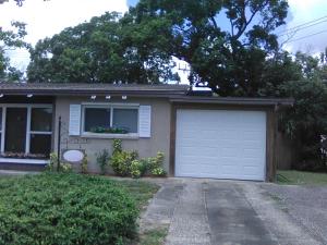 een klein huis met een garage en een raam bij 1 BEDROOM KITCHEn BATHROOM ApT in Titusville