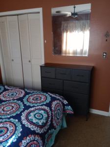 een slaapkamer met een bed, een ladekast en een spiegel bij 1 BEDROOM KITCHEn BATHROOM ApT in Titusville