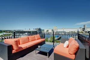 a balcony with two couches and a view of a city at Les Immeubles Charlevoix - Le 1166 in Quebec City