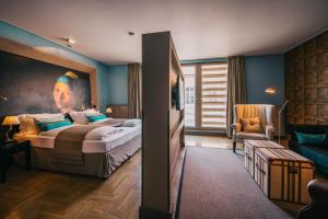 a bedroom with a bed with a painting of a woman at BALTAZÁR Boutique Hotel in Budapest