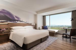守山琵琶湖万豪酒店的一间卧室，配有一张大床和一扇大窗户。