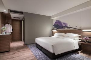 守山琵琶湖万豪酒店的卧室里有一张白色的床，墙上挂着一幅画 更多69张照片