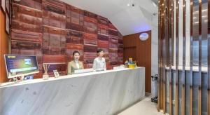 two people sitting at a counter in a restaurant at JTOUR Inn Wuhan Wusheng Road Metro CapitaLand Plaza in Wuhan