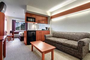 ein Wohnzimmer mit einem Sofa und ein Zimmer mit einem Bett in der Unterkunft Microtel Inn & Suites by Wyndham Bridgeport in Bridgeport