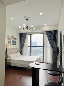a bedroom with a bed and a table and a window at Studio Apt OceanPark in Kon Rung (1)