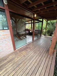 een houten terras met glazen deuren op een huis bij Loft no centrinho do Rosa in Imbituba