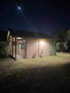 een klein huis 's nachts met de maan erboven bij Loft no centrinho do Rosa in Imbituba +3 foto's