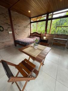 een kamer met een tafel en stoelen en een bed bij Loft no centrinho do Rosa in Imbituba