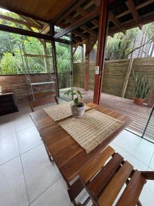 een houten tafel en stoelen op een terras bij Loft no centrinho do Rosa in Imbituba