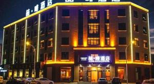 ein großes Gebäude mit seitlicher Beleuchtung in der Unterkunft James Joyce Coffetel Wuhan Gutian Er Road Metro Station in Wuhan