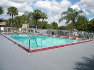 a large swimming pool with a metal fence around it at Econo Lodge Daytona Beach - Speedway in Daytona Beach