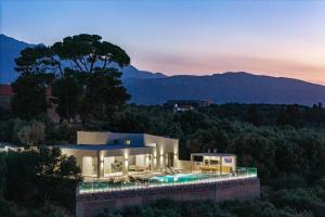 a villa with a swimming pool at dusk at Virtus in Mare in Tsivarás