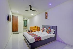 a hotel room with a bed and a chair at FabHotel RK Inn in Pune