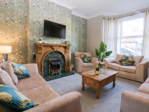 a living room with couches and a fireplace at Canning Lodge in Colwyn Bay