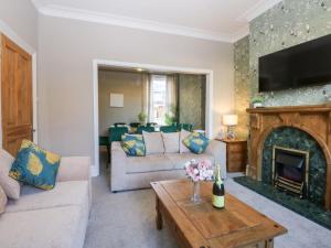 a living room with a couch and a fireplace at Canning Lodge in Colwyn Bay