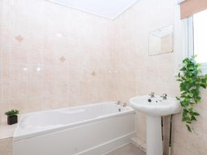 a bathroom with a white tub and a sink at Canning Lodge in Colwyn Bay +17 photos
