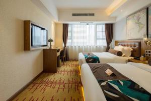 ein Hotelzimmer mit zwei Betten und einem Schreibtisch in der Unterkunft James Joyce Coffetel Kunming Railway Station Huancheng Nan Road Metro Station in Kunming