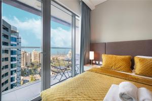 Un dormitorio con una cama y una ventana grande. en First Class Apartments in Seven Palm with direct Access to the West Palm Beach and Nakheel Mall, en Dubái 41 fotos más