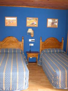 セルレルにあるCasa La Abadíaの青い壁のベッドルーム1室(ベッド2台付)