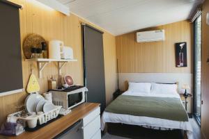 Konggu Valley Retreat Hut X By Tiny Away في T'ou-kou: غرفة نوم بها سرير وتلفزيون