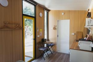 Konggu Valley Retreat Hut X By Tiny Away في T'ou-kou: غرفة فيها باب وطاولة وكراسي