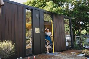 Konggu Valley Retreat Hut X By Tiny Away في T'ou-kou: امرأة تقف في مدخل منزل صغير +13 صورة