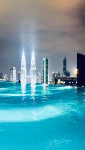 ein Wasserpool mit einer Stadt im Hintergrund in der Unterkunft Eaton Residence KLCC - Universal Home in Kuala Lumpur