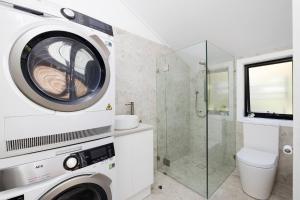 a washing machine in a bathroom with a shower at Solace by the Bay in Corlette +19 photos