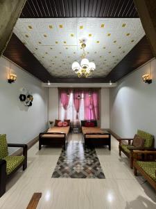 ein Wohnzimmer mit Sofas und einem Kronleuchter in der Unterkunft Hornbill Homes 1 in Kohīma + 8 Fotos