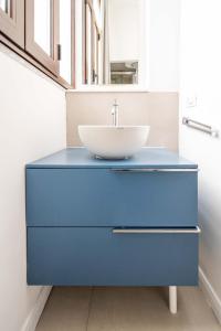 une salle de bain avec une commode bleue avec un lavabo dans l'établissement Palazzino San Francesco, à Catane