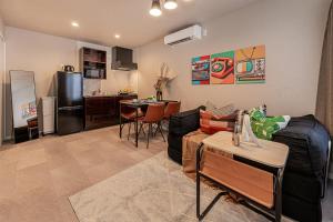 a living room with a couch and a kitchen at Mi-Hotel Kitashinjuku 北新宿 in Tokyo