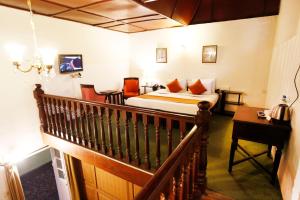 ein Hotelzimmer mit einem Bett und einer Treppe in der Unterkunft Belvedere Palace Nainital in Nainital