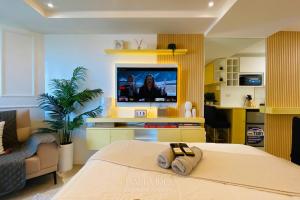 a living room with a bed and a tv in it at Bali Videl - Studio with Queen Bed & Beach View in San Fernando