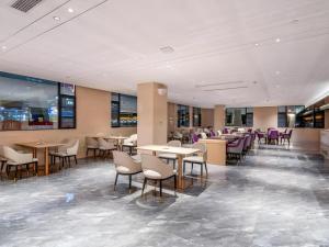 ein Restaurant mit Tischen, Stühlen und lila Stühlen in der Unterkunft Lavande Hotel Chaozhou Fortune Center Lin Street in Fengxi