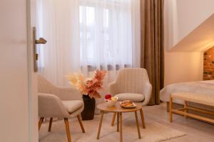 Un dormitorio con dos sillas y una mesa y una cama. en Kazimierz Residence Apartments by Staymoovers, en Cracovia