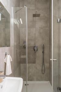 una ducha con puerta de cristal al lado de un lavabo en Kazimierz Residence Apartments by Staymoovers, en Cracovia